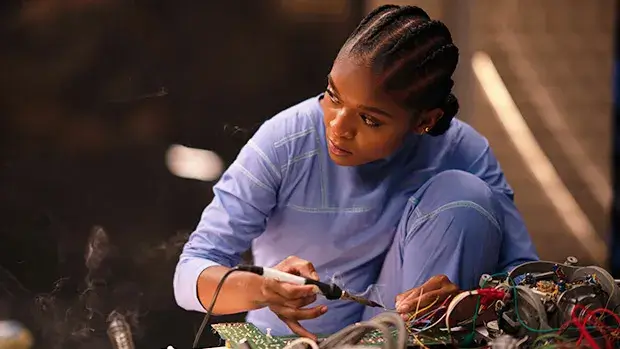 Dominique Thornein black panther wakanda forever working on some intricate eletrical equipment